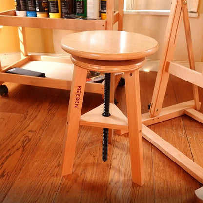 MEEDEN beech drafting stool positioned beside a studio easel