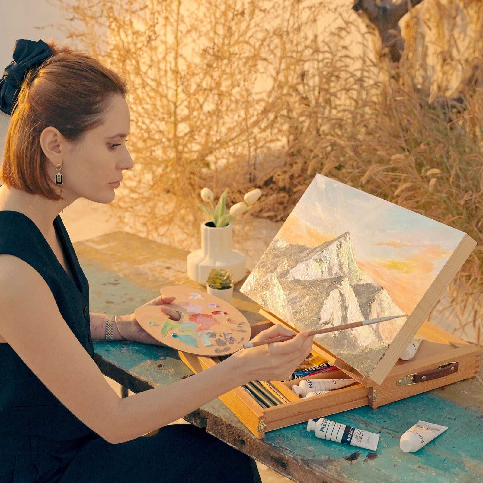 Artist painting with the MEEDEN tabletop easel and open storage drawer